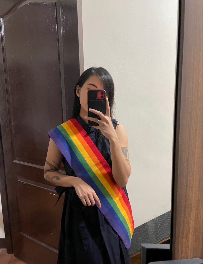 Sam's mirror selfie wearing a rainbow sash