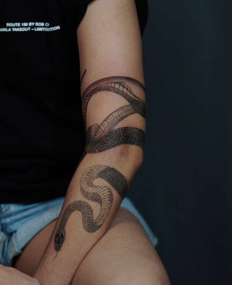 A photos of Sam's snake tattoo on her left arm