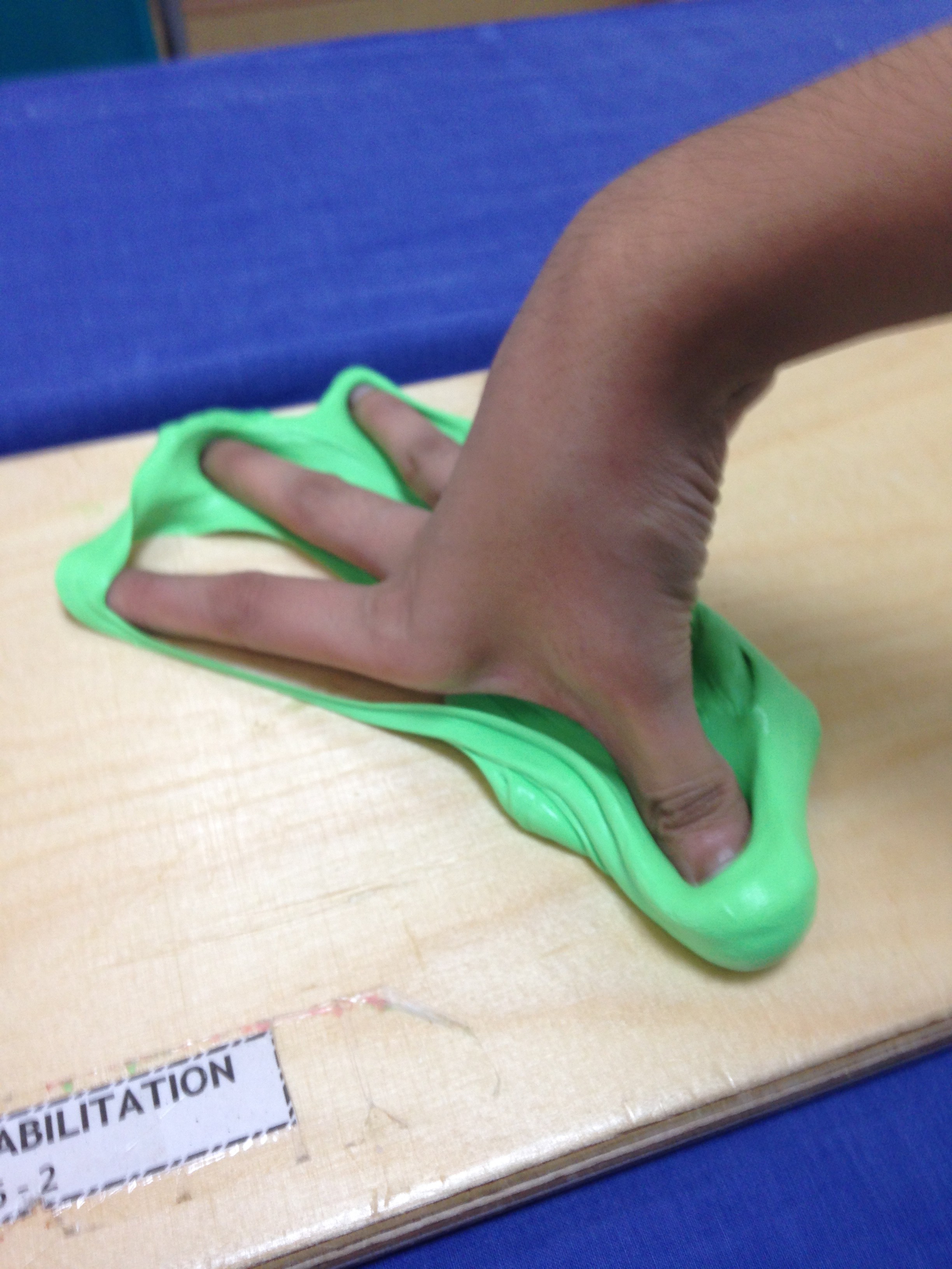 My hand trying to stretch out a therapy putty, a clay-like material for hand exercises